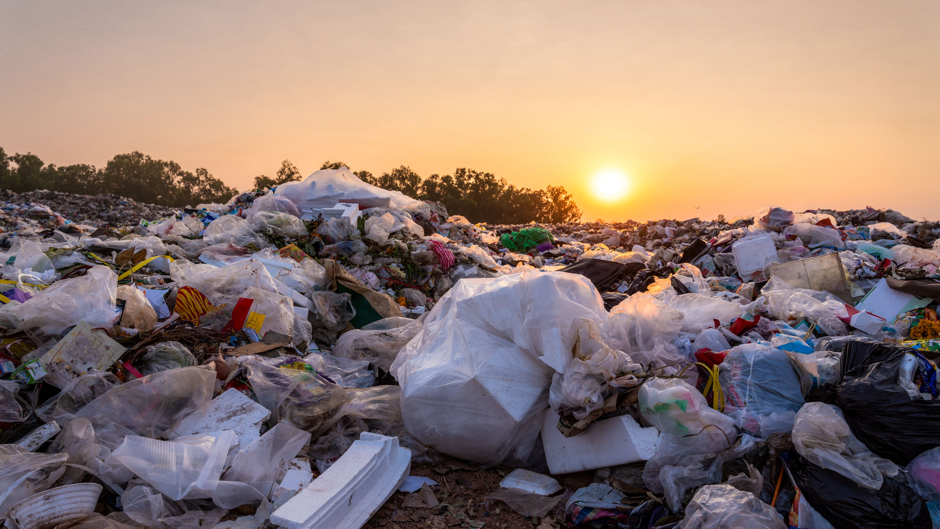 Close up large garbage pile at sunset