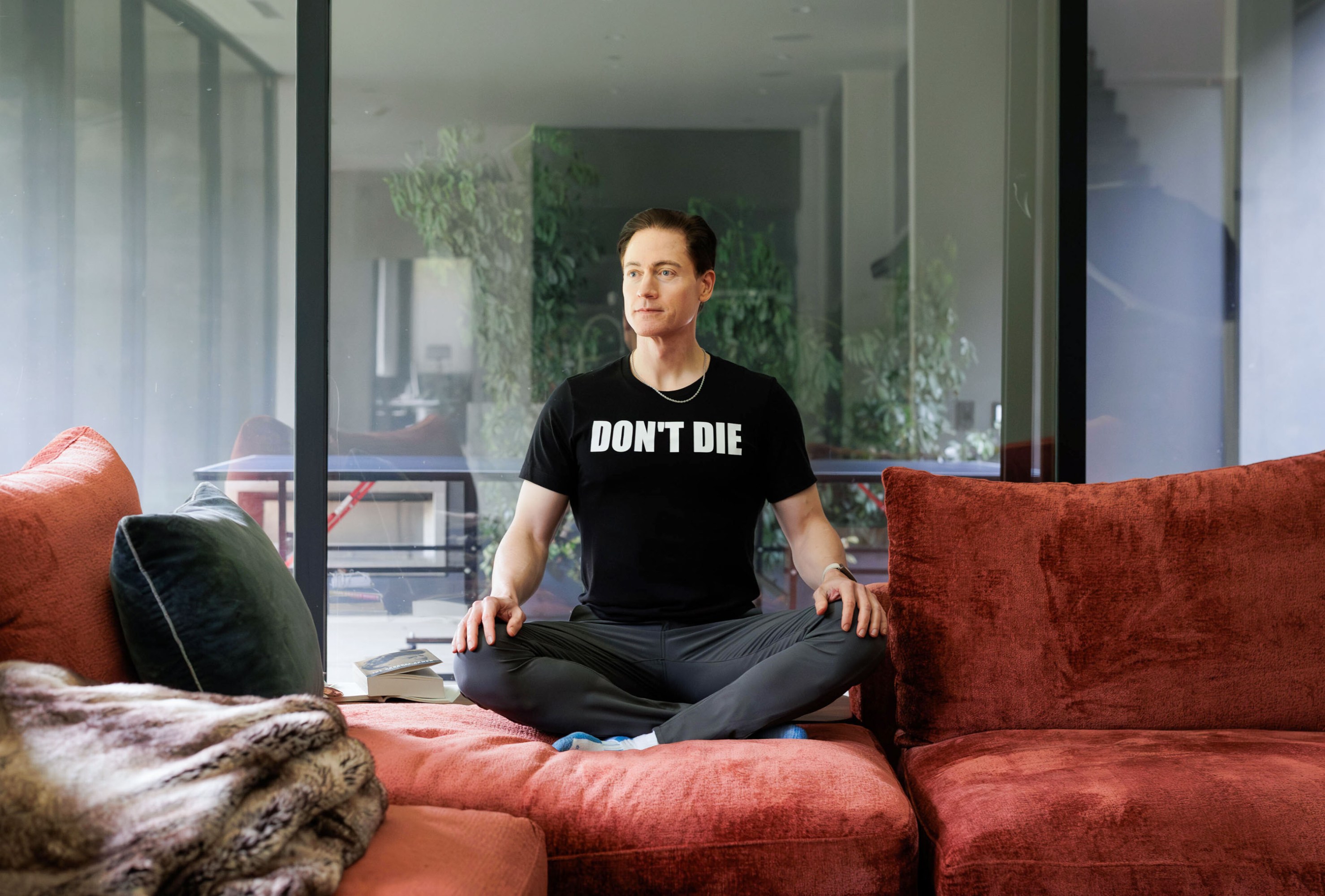 Bryan Johnson sitting cross-legged at home